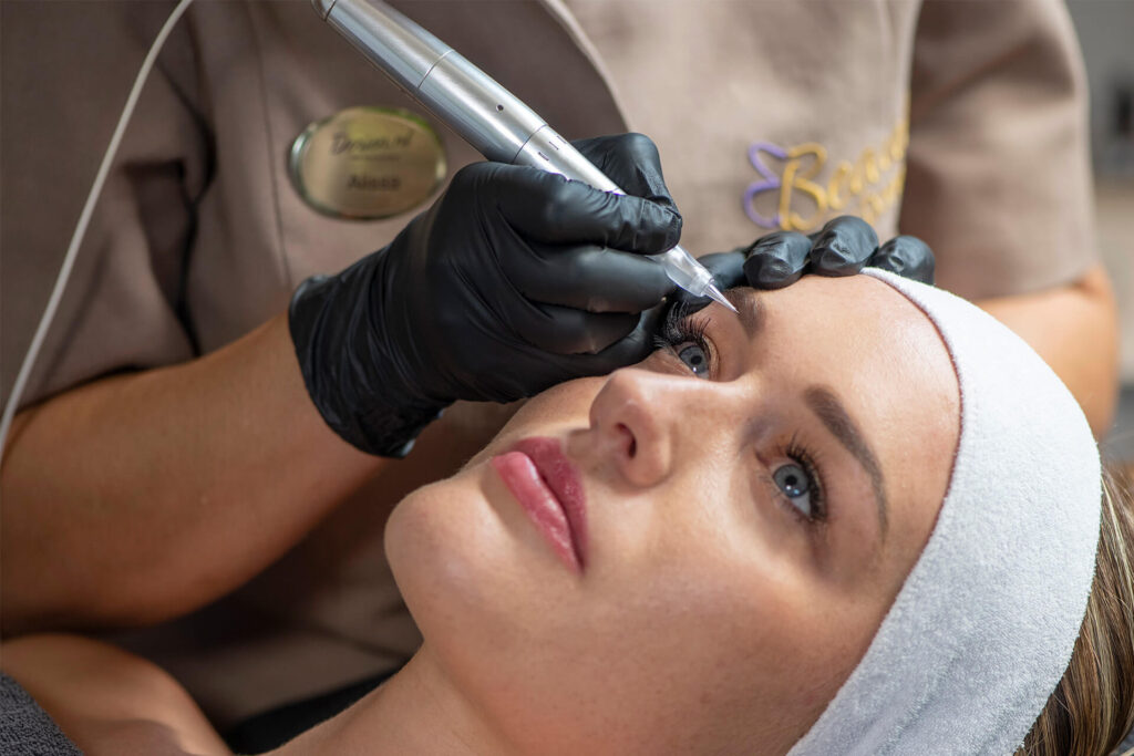 Permanente make up PMU wordt aangebracht op de wenkbrauwen van een vrouw